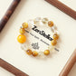 Amber Rise AI bracelet displayed on elegant tray with golden crystal beads and premium jewelry presentation