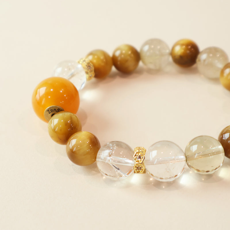 Close up of Amber Rise bracelet featuring Golden Tiger Eye patterns, Clear Quartz clarity, Golden Rutilated Quartz details and polished crystal finish