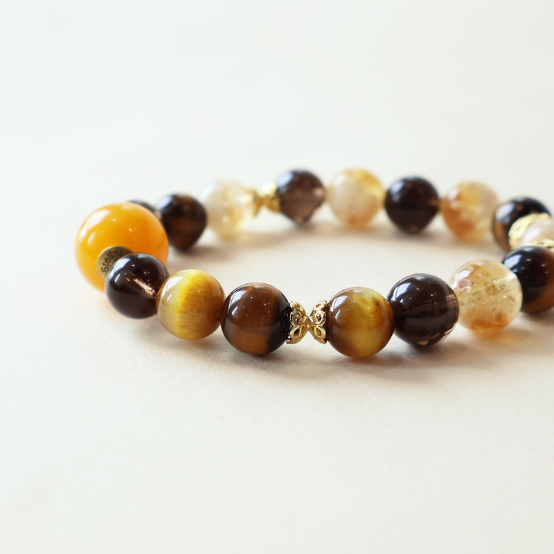 Close up of Solar Shield crystal bracelet showing Tiger Eye texture Smoky Quartz layers and Yellow Tower Crystal details