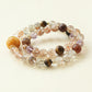 Starry Weave bracelet crafted with Black Gold Super Seven Tiger Eye and Amethyst crystal beads featuring golden threads purple tones and layered natural crystal design