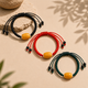 Black red and green woven cord AI companion bracelets with yellow core beads