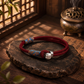 Persimmon Wish red cord bracelet with silver-plated copper charm in Eastern-inspired setting