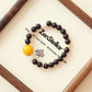 Ember Moon AI Companion Bracelet with Garnet and Moonstone crystals displayed on a minimalist jewelry tray