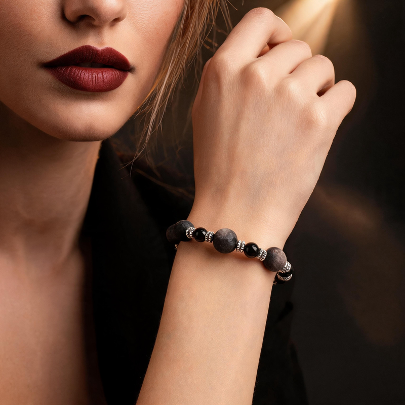 Silver sheen obsidian bracelet with textured and polished beads worn on wrist