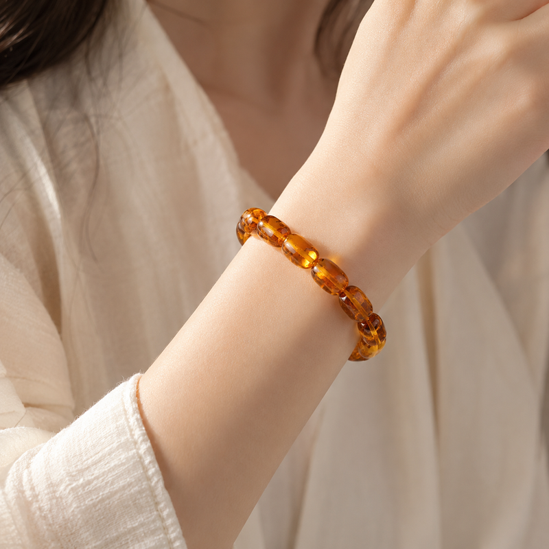 Polished amber bead bracelet worn on the wrist with a neutral linen outfit