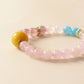 Close up of Rose Dream bracelet featuring Rose Quartz texture, Strawberry Quartz details, Blue Chalcedony beads and polished crystal finish