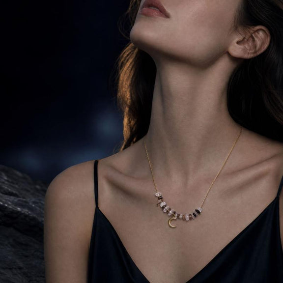 Ice obsidian and clear quartz crescent moon necklace worn on neck