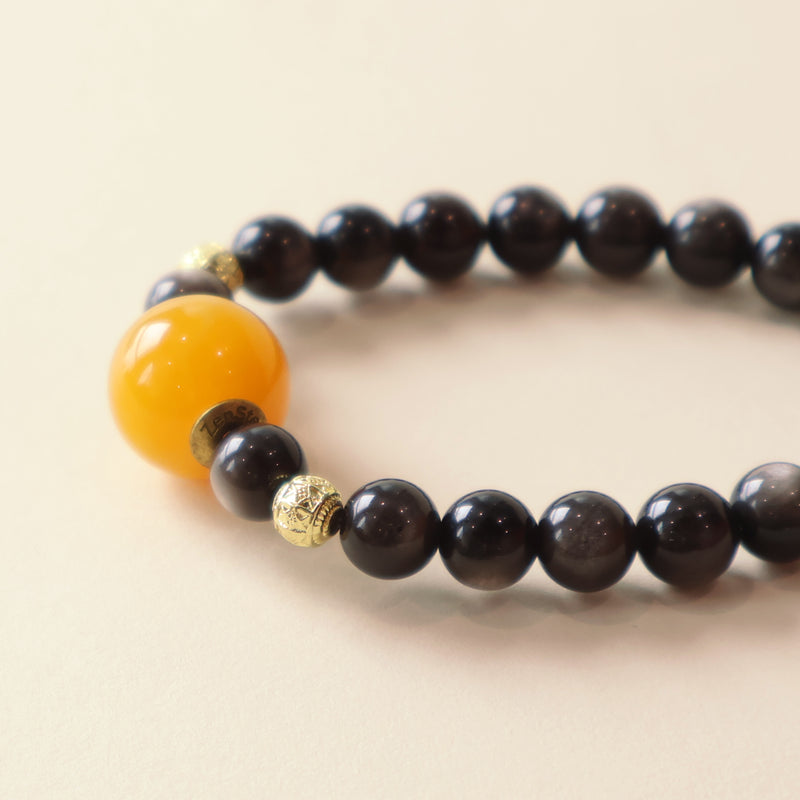 Close up view of Starry Shield bracelet highlighting silver obsidian crystal texture, glossy black beads and craftsmanship