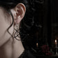 Black spinel spiderweb earrings worn with gothic styling