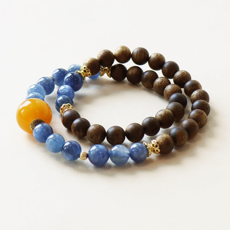 Close up of natural agarwood and kyanite bead bracelet featuring blue gemstone beads and handcrafted details