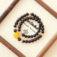 Cinder Motion Pulse AI Companion Bracelet displayed on Zenstellar presentation card with warm ambient lighting highlighting Garnet and Golden Rutilated Quartz energy design