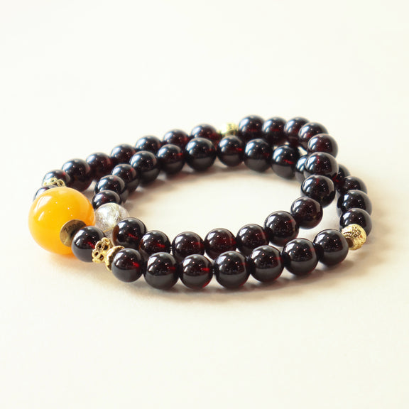 Cinder Motion Pulse Crystal Bracelet featuring natural Garnet and Golden Rutilated Quartz gemstone beads with AI companion bead in clean studio white background presentation