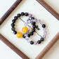 Dusk Whisper AI couple companion bracelet detail display with natural Gold Obsidian and Purple Rutilated Quartz crystals