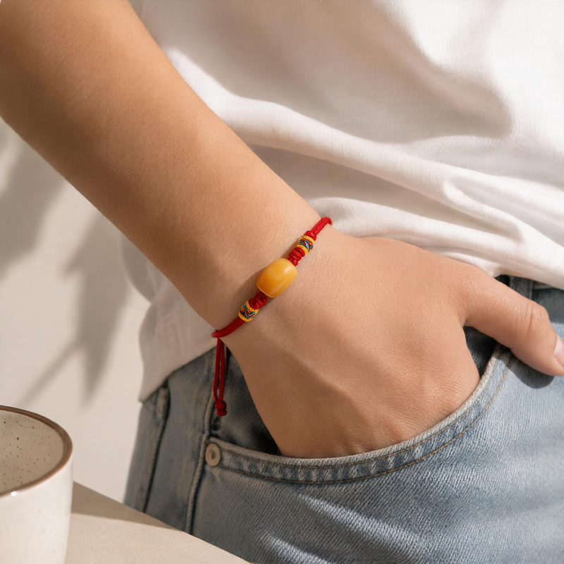 Red adjustable cord AI companion bracelet worn on wrist