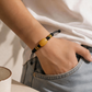 Black adjustable cord AI companion bracelet worn on wrist
