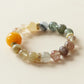 Close-up of a rutilated quartz crystal bracelet featuring 10mm natural gemstone beads with golden thread inclusions, transparent quartz layers, and warm earthy tones, designed as an elegant AI companion bracelet for mindful daily wear.