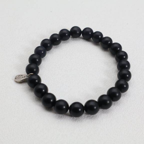 Detail of the 925 sterling silver charm on a black jade bead bracelet