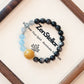 Nocturne Tide Essence AI Companion Bracelet displayed on Zenstellar presentation card with warm ambient lighting highlighting Silver Obsidian, Aquamarine, and Gray Moonstone crystal design