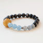 Nocturne Tide Essence Crystal Bracelet featuring natural Silver Obsidian, Aquamarine, and Gray Moonstone gemstone beads with AI companion bead in clean studio white background presentation