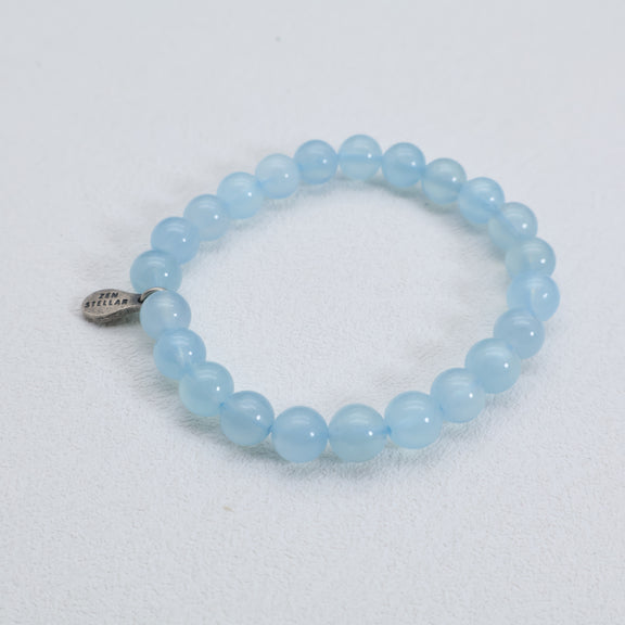 Full view of the Ocean Whisper aquamarine bracelet showing its round pale blue beads and silver charm