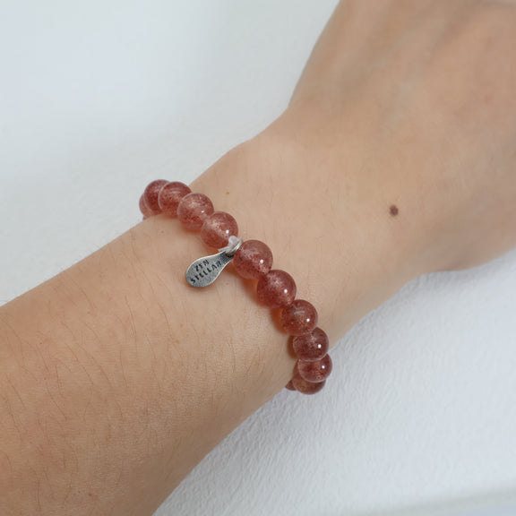 Close-up of 7mm strawberry quartz beads showing rosy tones and delicate red inclusions