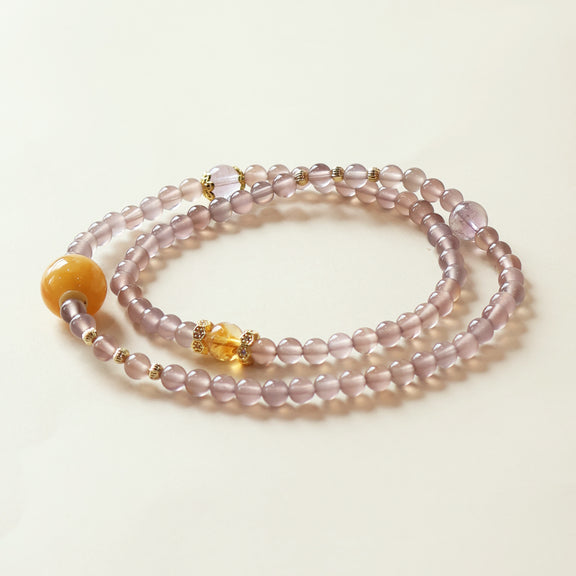Purple agate and amethyst crystal bracelet with citrine accent bead displayed on clean white background showing natural gemstone clarity