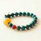Close-up view of Verdant Lattice Quiet Crystal Bracelet showing 8mm Malachite and Red Agate gemstone beads with butterfly accent and polished crystal texture