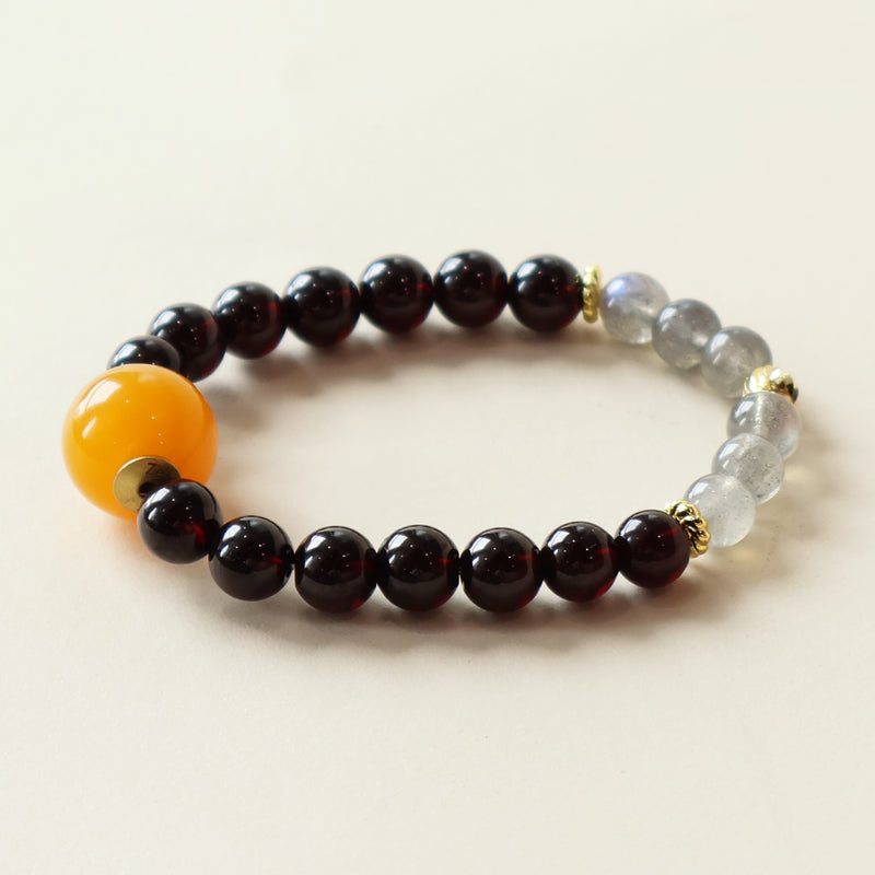 Close-up view of natural Garnet and Grey Moonstone beads highlighting crystal texture and organic gemstone patterns.